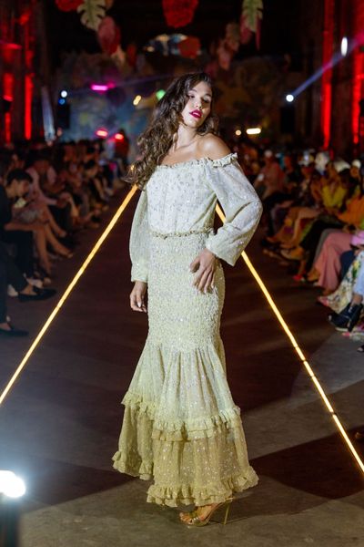 Rochie 74 – THE CREATION MOON lunga, eleganta, ivoire, din material elastic accesorizat cu micropaiete argintii, cu maneci lungi, cu umerii goi, gofrata in zona taliei si soldurilor, 2 volane in partea de jos