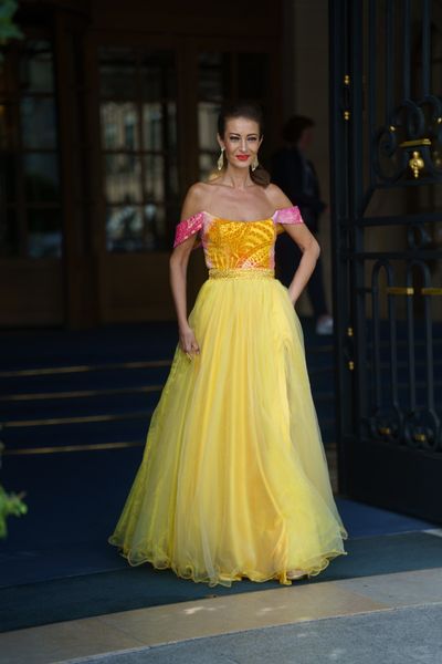 Rochie SOLARIA PRINCESS din voal galben cu accente fuchsia, cu insertii de catifea si cristale colorate, si organza galbena, lunga, cu fante (aplicatii) din material pe ambele maini, prinse de corset