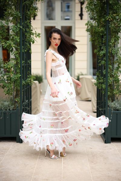 Rochie SOLARIA BLANCHE din dantela alba cu broderie de flori mici, multicolore, pe care au fost aplicate manual cristale muticolore, cu aplicatii din bumbac alb, lunga, fara maneci