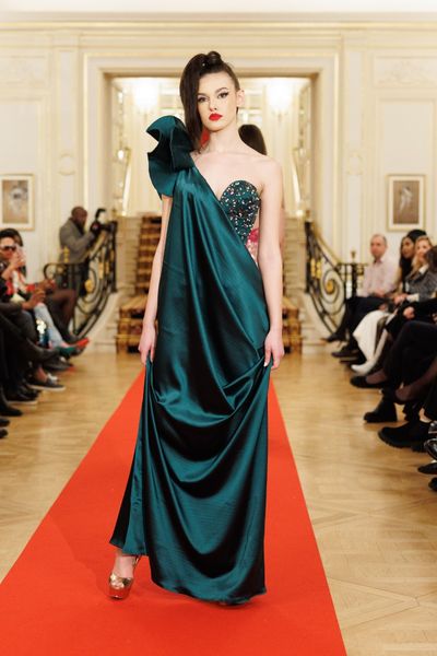 Rochie STRONG GODESS lunga, fara maneci, cu corset, din tul verde cu broderie din cristale multicolore si perle, peste care am aplicat de pe umarul drept pana jos satin elastic verde, cu un element decorativ volumetric din satin elastic verde pe umar