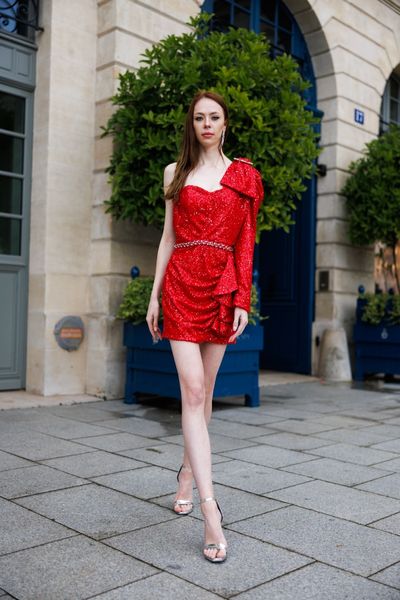 Rochie STRONG HOT scurta, asimetrica, doar cu o maneca, din tul rosu cu paiete rosii aplicat peste satin rosu elastic, cu o funda mare pe umar, catarama cu cristale argintii aplicata peste funda si banda din cristale argintii in talie