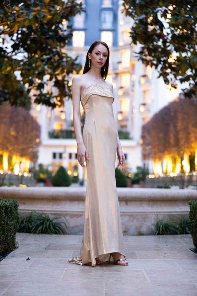 Rochie STRONG BEAUTY lunga, fara maneci, cu decolteu, cu spatele gol, din material elastic auriu metalizat, cu o aplicatie din tul auriu cu broderie din margele aurii pe bust, cu o trena scurta 