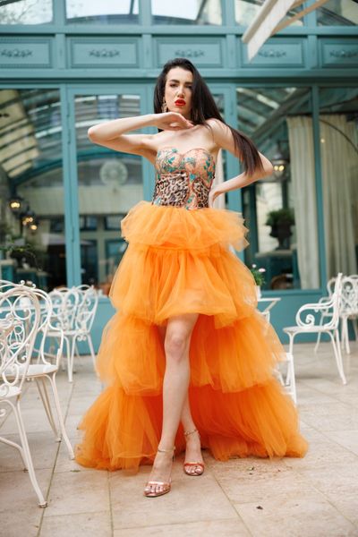 Rochie SOLARIA BELLEZZA asimetrica, scurta si fata si lunga in spate, cu corset, fara maneci, in partea de sus dintr-o dantela tip plasa cu aplicatii din material cu design animal print si paiete, iar in partea de jos din tul elastic portocaliu